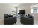 Bright living room featuring neutral walls, tile flooring, and sliding glass doors to backyard at 2340 Grasmere View S Pkwy, Kissimmee, FL 34746