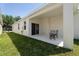 Covered patio area with chairs, a table, and a sliding glass door to the home's interior at 2340 Grasmere View S Pkwy, Kissimmee, FL 34746