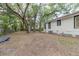 Large backyard with mature trees and white home with black trim at 2504 Yale Ave, Sanford, FL 32773