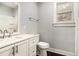 Well-lit bathroom featuring white vanity with modern fixtures, a toilet, and a window for natural light at 2504 Yale Ave, Sanford, FL 32773