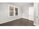 Inviting bedroom featuring sleek, dark wood floors and minimalist decor, illuminated by natural light from two windows at 2504 Yale Ave, Sanford, FL 32773
