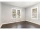 Sunlit bedroom with hardwood floors, complemented by fresh, neutral paint and two bright windows at 2504 Yale Ave, Sanford, FL 32773
