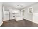 Modern kitchen with white cabinetry, island, stainless appliances, and dark hardwood floors at 2504 Yale Ave, Sanford, FL 32773