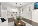 Open kitchen with white cabinetry, stainless steel appliances, breakfast bar, and hardwood floors at 2504 Yale Ave, Sanford, FL 32773