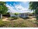 Lush backyard featuring a screened patio, mature trees, and a stone path at 2707 Chelsea St, Orlando, FL 32803