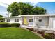 Charming one-story home with a well-manicured lawn, minimalist yard art, and a bright yellow front door at 2707 Chelsea St, Orlando, FL 32803