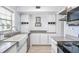 Modern kitchen with white cabinets, light countertops, stainless steel appliances, and updated fixtures at 2707 Chelsea St, Orlando, FL 32803