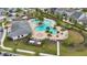Aerial view of community pool with lounge chairs, tropical palms, clubhouse, playground and manicured lawns at 2934 Title St, Kissimmee, FL 34746