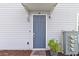 Stylish blue front door with modern hardware, digital lock and smart doorbell, framed by gray siding at 2934 Title St, Kissimmee, FL 34746