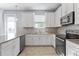 Bright kitchen featuring white cabinetry, stainless appliances, and a large window over the sink at 2934 Title St, Kissimmee, FL 34746