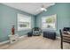 Bright bedroom with light wood floors, two windows, ceiling fan, and aqua colored walls at 2945 Juniper Dr, Edgewater, FL 32141