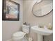 Powder room featuring a pedestal sink, round mirror, decorative art, and white fixtures for a clean and functional space at 3015 Dawley Ave, Orlando, FL 32806