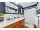Elegant bathroom with dark blue walls, wood-framed mirror, and a classic double vanity with white countertops at 3015 Dawley Ave, Orlando, FL 32806