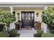 Close-up of the elegant front door with decorative wreath, sconces, and potted flowers at 3015 Dawley Ave, Orlando, FL 32806