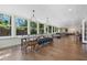 Bright living area with oversized windows, wood floors, long wood dining table, and views of the outdoor landscape at 3015 Dawley Ave, Orlando, FL 32806
