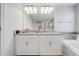 Bright bathroom featuring double sinks, granite countertops, and white cabinets at 3312 Cordgrass Pl, St Cloud, FL 34773
