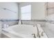Bright bathroom featuring a large tub with gray tile accents at 3312 Cordgrass Pl, St Cloud, FL 34773