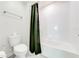 Clean bathroom featuring a shower-tub combo and a white tiled surround at 3312 Cordgrass Pl, St Cloud, FL 34773