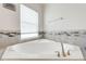 Close-up of a modern corner bathtub with tile surround and elegant fixtures at 3312 Cordgrass Pl, St Cloud, FL 34773