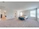 Bright, oversized bedroom with neutral carpet, two windows, and an en-suite bath at 3312 Cordgrass Pl, St Cloud, FL 34773
