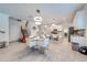 Open-concept dining area with modern chandelier, tile floors, and access to kitchen and staircase at 3312 Cordgrass Pl, St Cloud, FL 34773