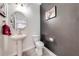 Stylish half bathroom with unique wall decor, modern fixtures, and a sleek pedestal sink at 3312 Cordgrass Pl, St Cloud, FL 34773