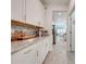 Hallway leading to a modern kitchen with granite countertops, stainless steel appliances and white cabinets at 3312 Cordgrass Pl, St Cloud, FL 34773