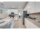 Open kitchen featuring white cabinetry, granite counters, stainless appliances, and a breakfast bar at 3312 Cordgrass Pl, St Cloud, FL 34773