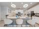 Modern kitchen island featuring granite countertop, white cabinets, pendant lights, and bar stools at 3312 Cordgrass Pl, St Cloud, FL 34773