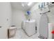 Functional laundry room equipped with modern washer, dryer, and shelving for storage at 3312 Cordgrass Pl, St Cloud, FL 34773