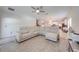 Spacious living room featuring a large white sectional sofa, tile flooring, and a ceiling fan at 3312 Cordgrass Pl, St Cloud, FL 34773