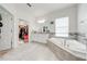 Bright main bathroom with a soaking tub, double vanity, walk-in closet, and tile flooring at 3312 Cordgrass Pl, St Cloud, FL 34773
