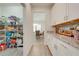 Well-organized pantry and white cabinets with granite countertops and stylish backsplash, leading to the dining area at 3312 Cordgrass Pl, St Cloud, FL 34773