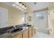 Bathroom with dual sinks, granite countertop and tile surround bathtub and shower at 3331 Morelyn Crest Cir, Orlando, FL 32828