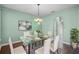 Bright dining room features modern light fixture, glass table, and seating for six at 3331 Morelyn Crest Cir, Orlando, FL 32828