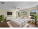 A well-lit main bedroom offering wood floors, a luxurious bed, and plentiful natural light at 3331 Morelyn Crest Cir, Orlando, FL 32828