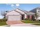 Charming single-story home featuring a two-car garage, well-manicured lawn, and red shutters at 3529 Yarian Dr, Haines City, FL 33844