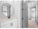 Bathroom featuring modern vanity, round mirror, sleek fixtures and access to multiple rooms at 3608 Dubsdread Cir, Orlando, FL 32804