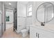 Modern bathroom featuring white vanity, black fixtures, round mirror and access to a glass enclosed shower at 3608 Dubsdread Cir, Orlando, FL 32804