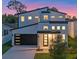 Modern two-story home with a black garage door, minimalist landscaping, and a sleek front door at 3608 Dubsdread Cir, Orlando, FL 32804