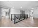 Spacious upstairs hallway with hardwood floors and black metal railing leading to the stairway at 3608 Dubsdread Cir, Orlando, FL 32804