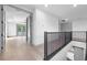 Spacious upstairs hallway with hardwood floors and black metal railing leading to the stairway at 3608 Dubsdread Cir, Orlando, FL 32804