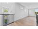 Light-filled hallway features wood floors, neutral walls, and modern railing at 3608 Dubsdread Cir, Orlando, FL 32804