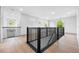 Bright hallway featuring hardwood floors, modern black railings, and ample natural light from multiple windows at 3608 Dubsdread Cir, Orlando, FL 32804