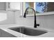 Close-up of a modern kitchen sink with a stylish faucet and white backsplash at 3608 Dubsdread Cir, Orlando, FL 32804