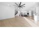 A spacious living room flows into an open-concept kitchen with modern lighting fixtures and hardwood floors at 3608 Dubsdread Cir, Orlando, FL 32804