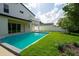 Backyard showcasing a modern pool, lush green lawn, and an elegant two-story home at 3608 Dubsdread Cir, Orlando, FL 32804