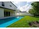 Backyard featuring a modern pool with blue tile, lush green lawn and a stylish two-story home at 3608 Dubsdread Cir, Orlando, FL 32804