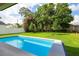 Backyard pool surrounded by lush green landscaping, mature trees, and a white fence for privacy at 3608 Dubsdread Cir, Orlando, FL 32804