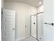 A luxurious shower with clear glass and modern fixtures sits next to a door leading to another room at 4278 Sagefield Dr, St Cloud, FL 34773